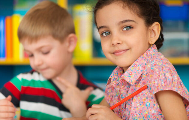 Cute little children drawing and studying at daycare
